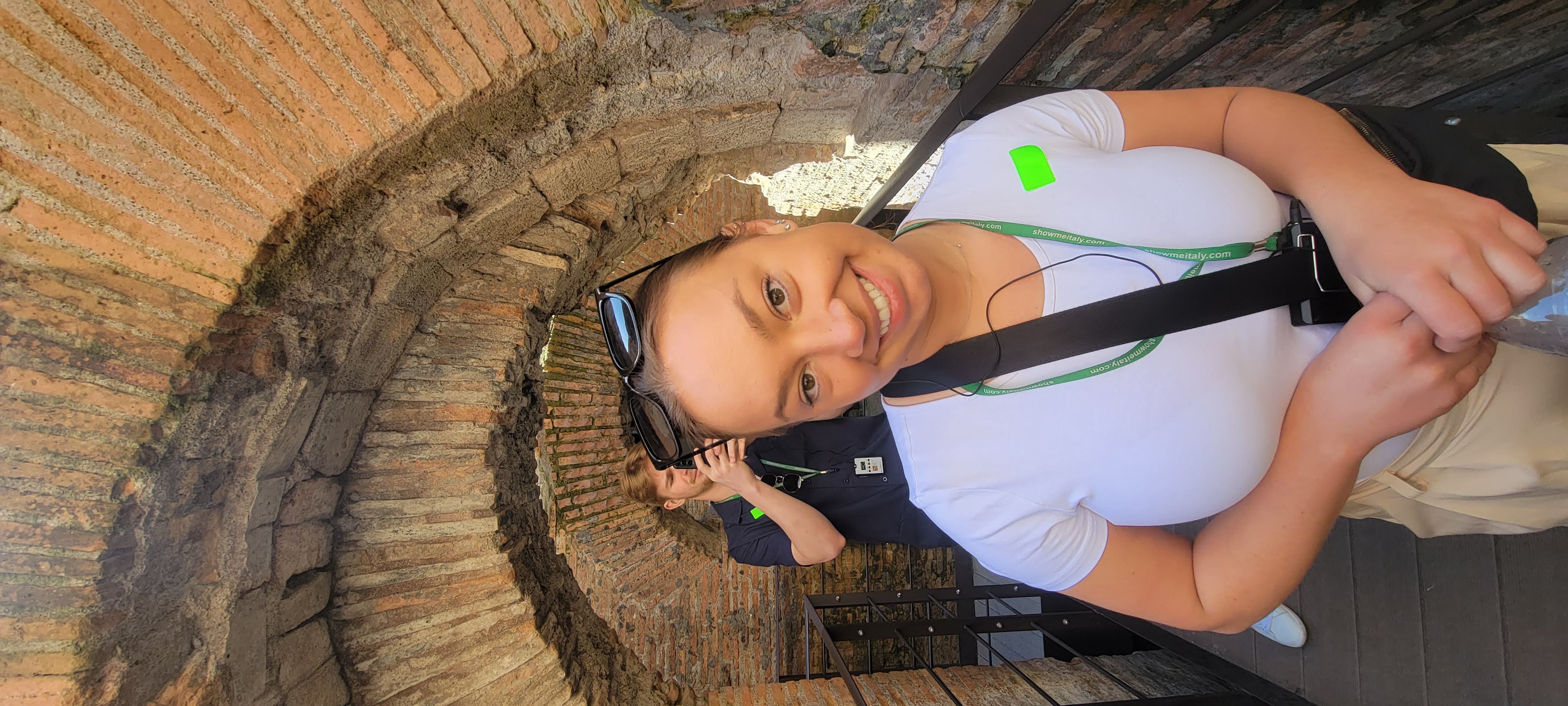 Erin smiling during a visit to a historic stone site in Italy.